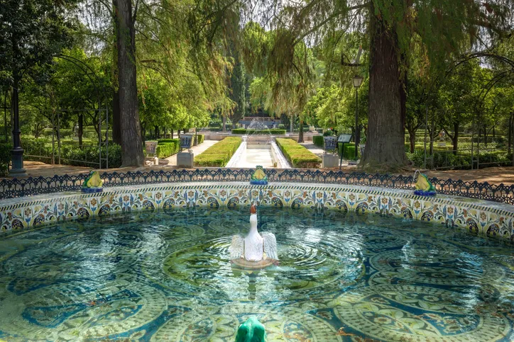 Fuente de las Ranas en el Parque de María Luisa de Sevilla, con su pato central, azulejos y una avenida de árboles al fondo