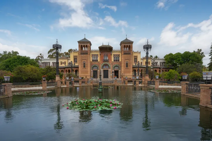 Pabellón Mudéjar de Aníbal González en la Plaza de América, sede del Museo de Artes y Costumbres Populares, reflejado en el estanque