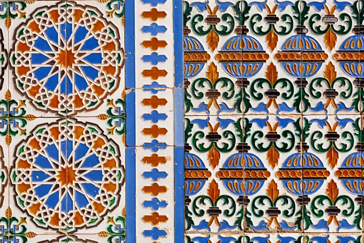 Azulejos sevillanos de motivos geométricos y florales en azul, naranja y verde, de la fábrica de cerámica La Cartuja de Sevilla